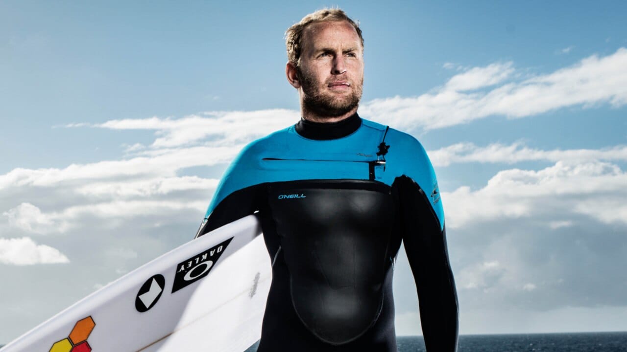 Mark Mathews holding a surfboard
